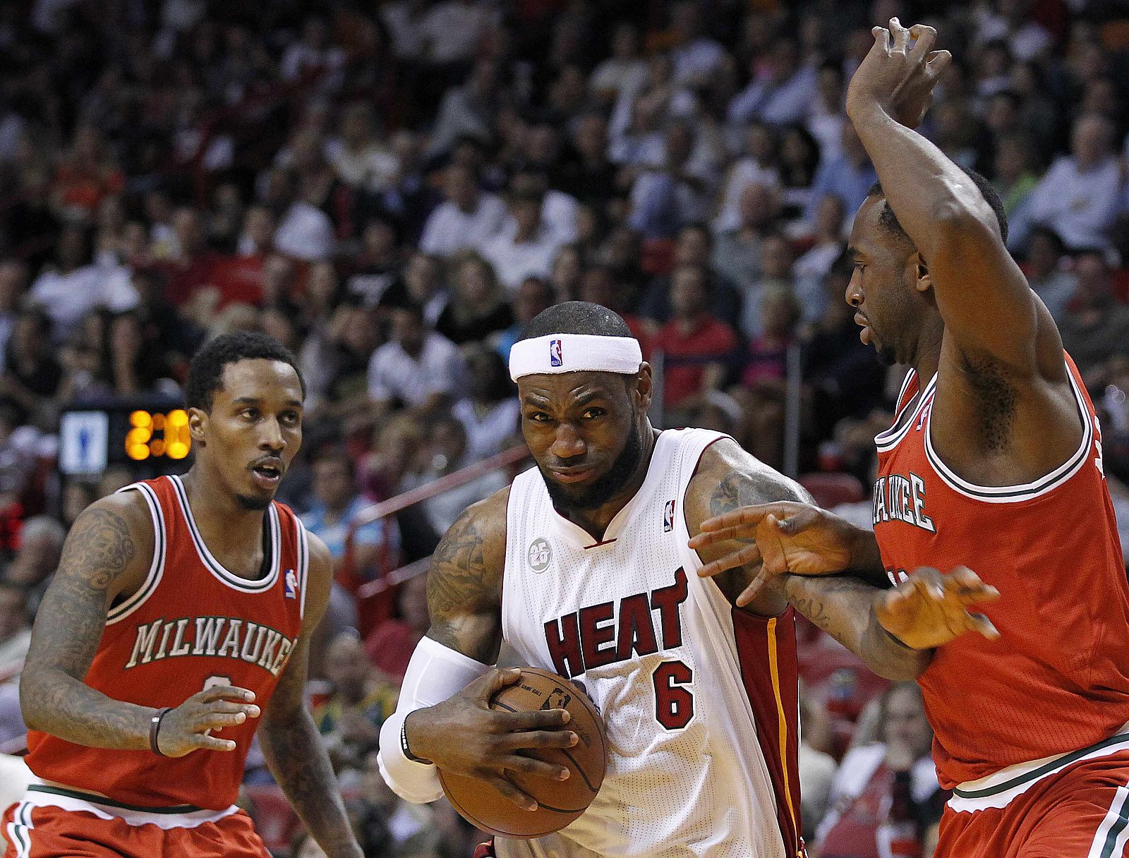 Milwaukee Bucks' Jennings looks in as Miami Heat's James tries to avoid Bucks' Moute in the first half of their NBA basketball game in Miami, Florida