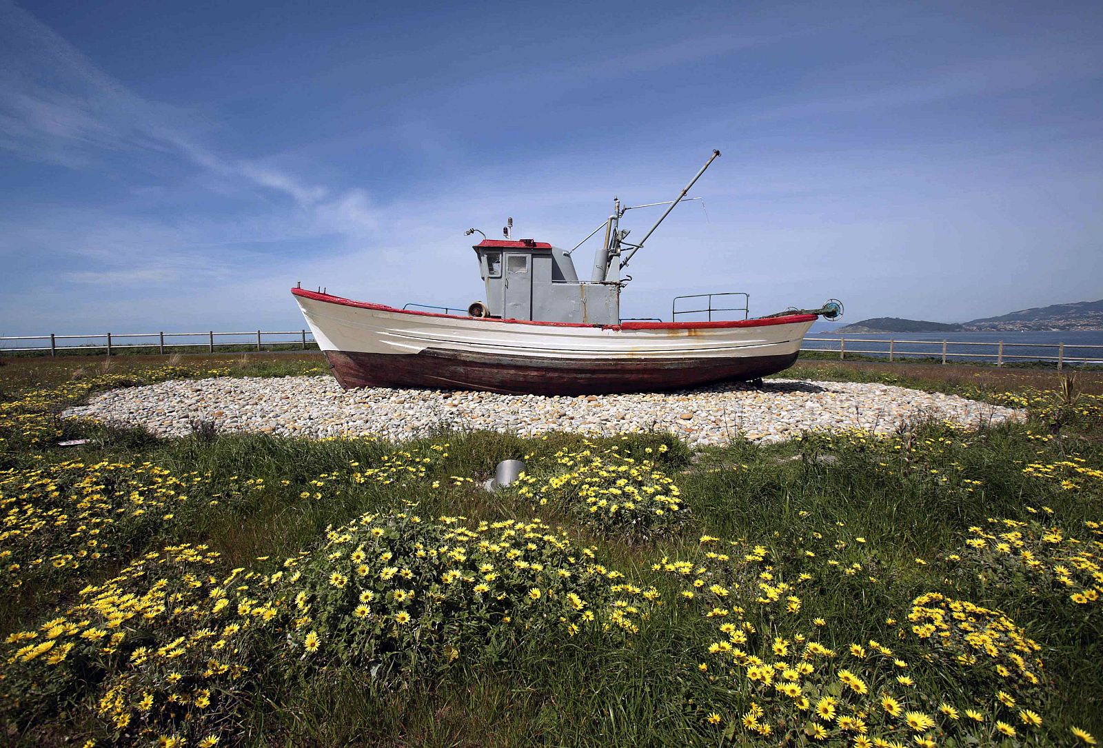 Un viejo barco de pesca decora un jardín de una factoría de Pescanova en Baiona