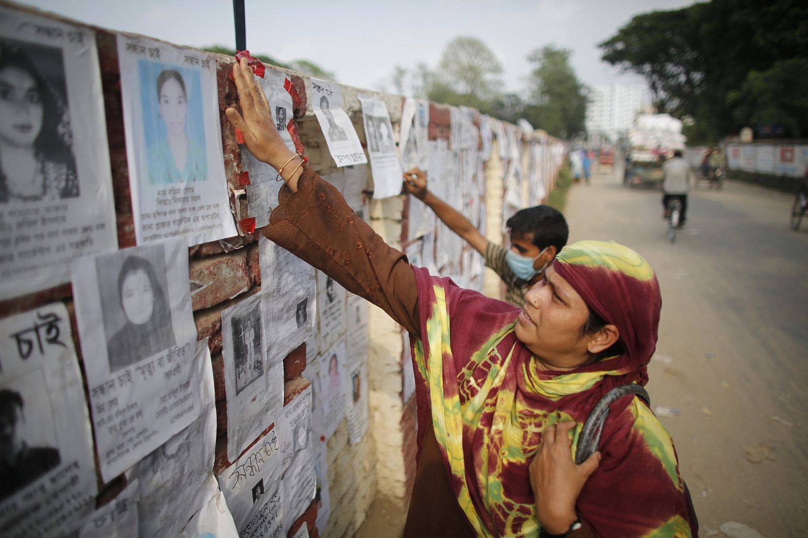 Woman checks for the name of her missing relatives, garment workers, who are missing after the collapse of Rana Plaza building in Savar