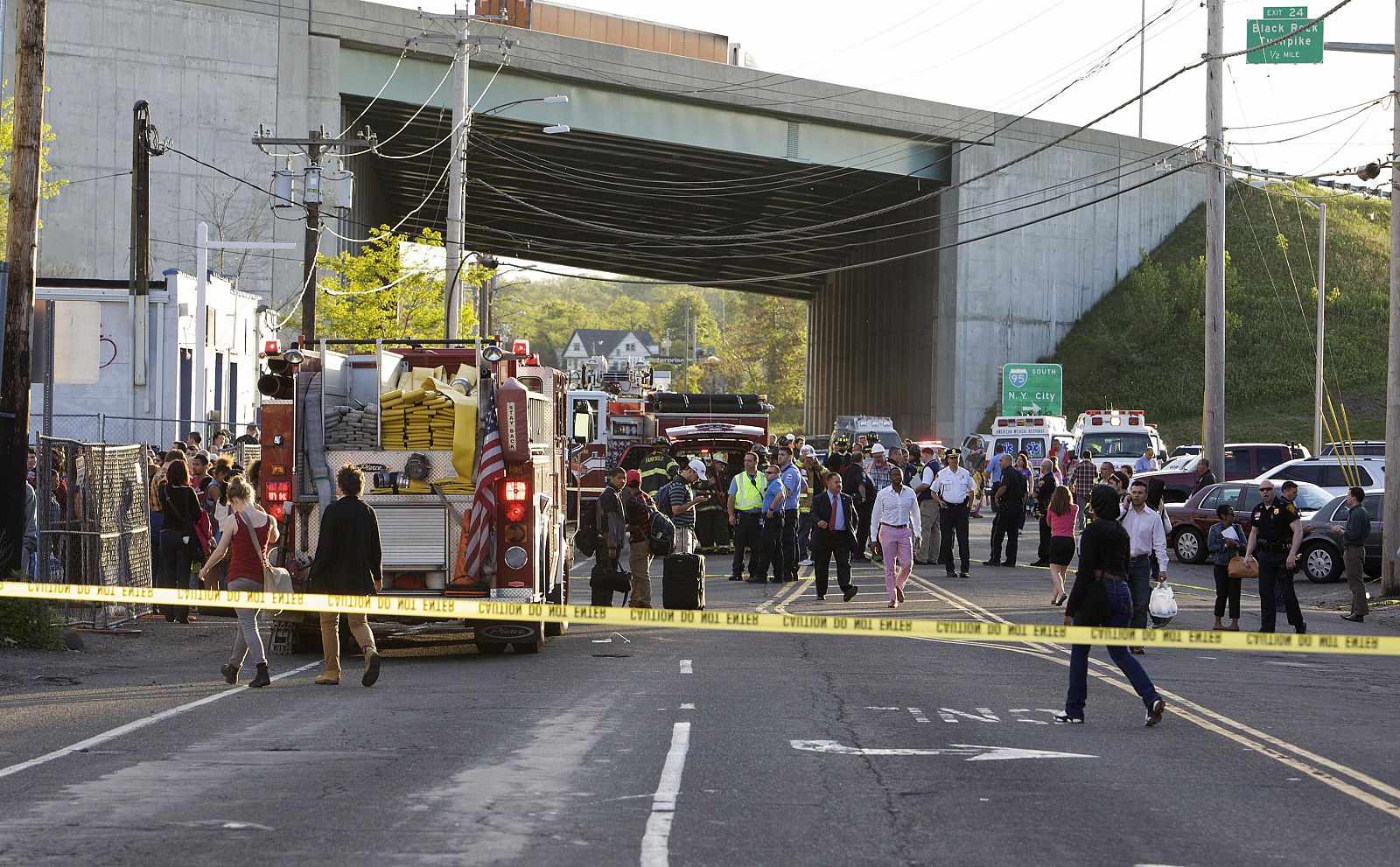 Emergency personnel and onlookers gather at the scene of a collision of two commuter trains in Bridgeport