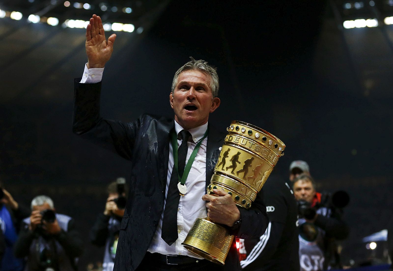 Bayern Munich's coach Heynckes holds the trophy after he was showered with beer as his team celebrates victory over VfB Stuttgart in their German soccer cup (DFB Pokal) final match at the Olympic Stadium in Berlin