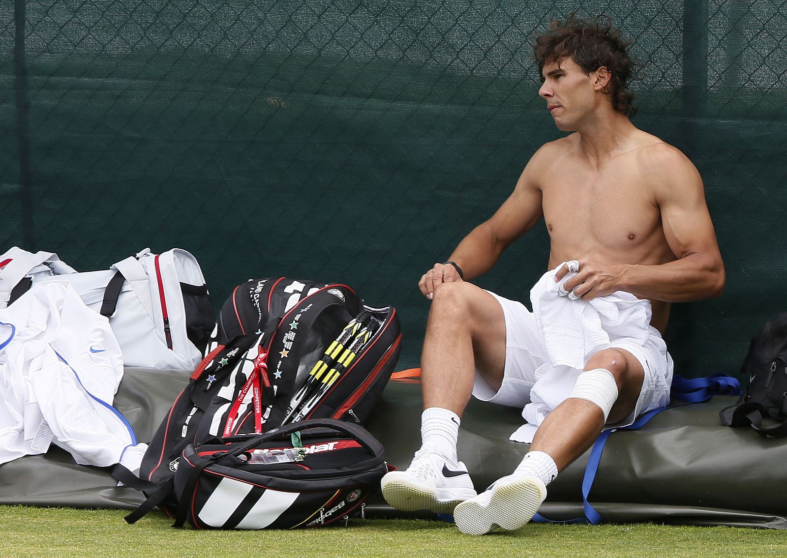 Rafael Nadal changes his shirt during a training session at Wimbledon in London