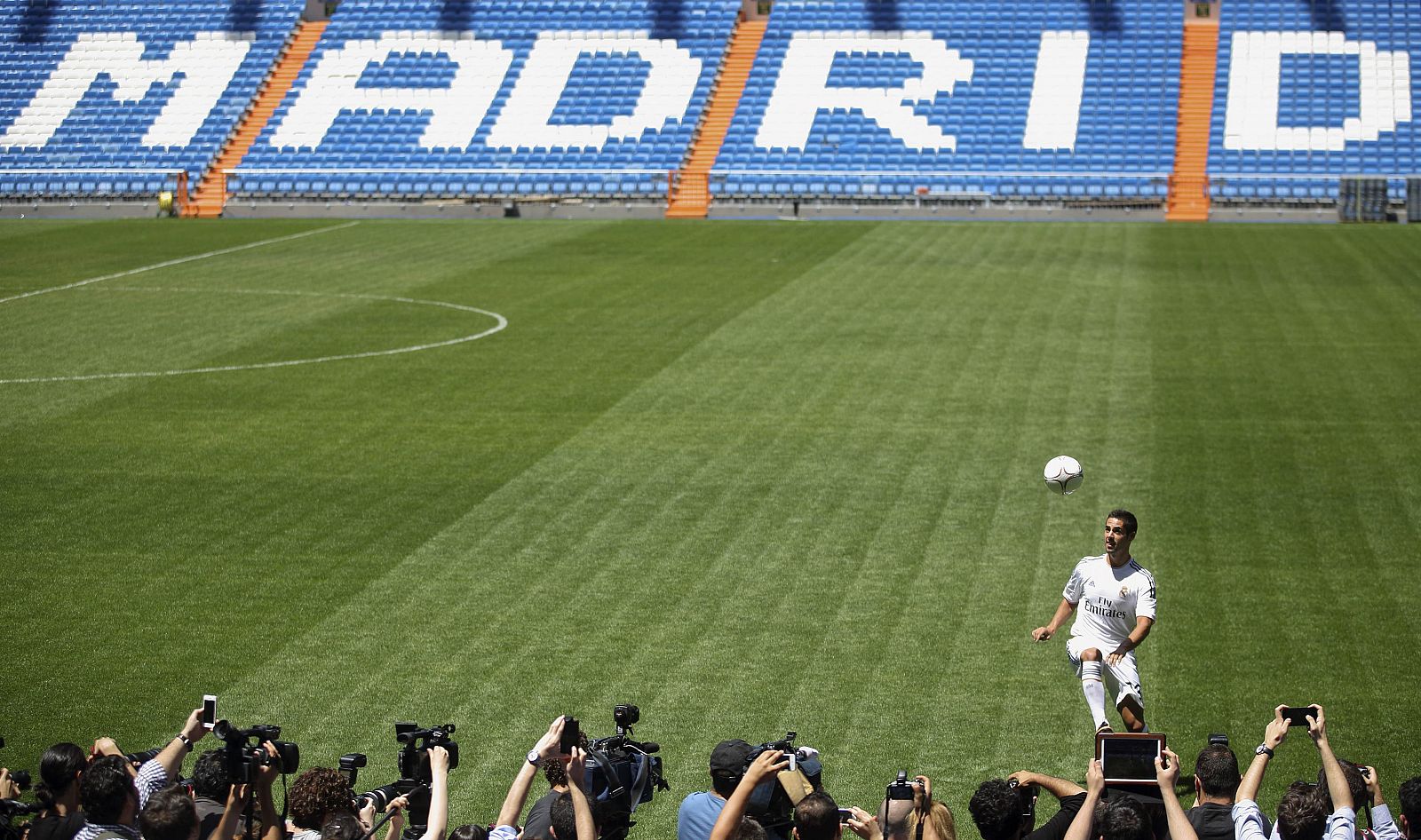 Real Madrid's new signing Isco juggles a ball during his presentation at Santiago Bernabeu stadium in Madrid