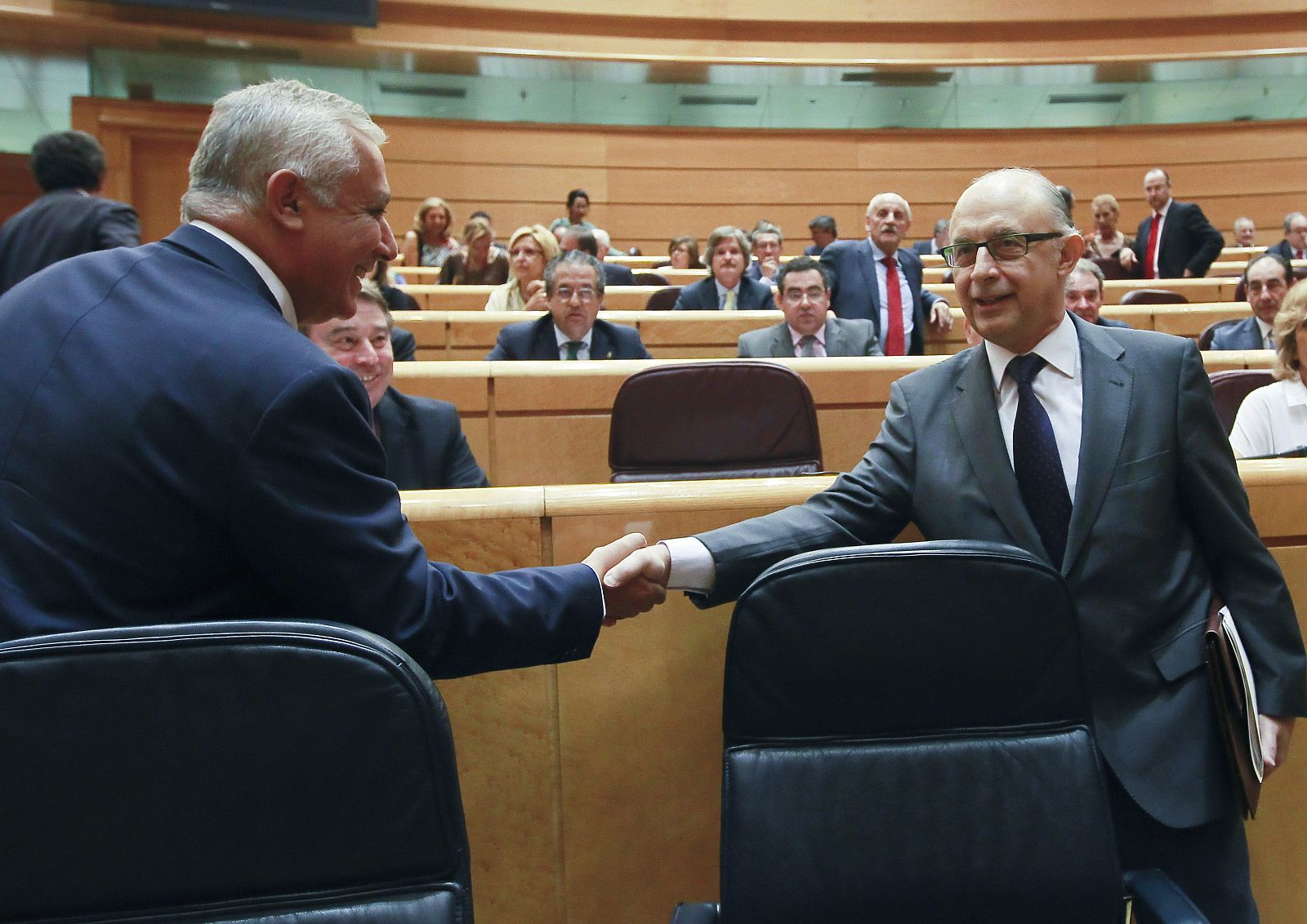 El ministro de Hacienda y Administraciones Públicas, Cristóbal Montoro, saluda al vicesecretario de Política Autonómica y Local del PP, Javier Arenas