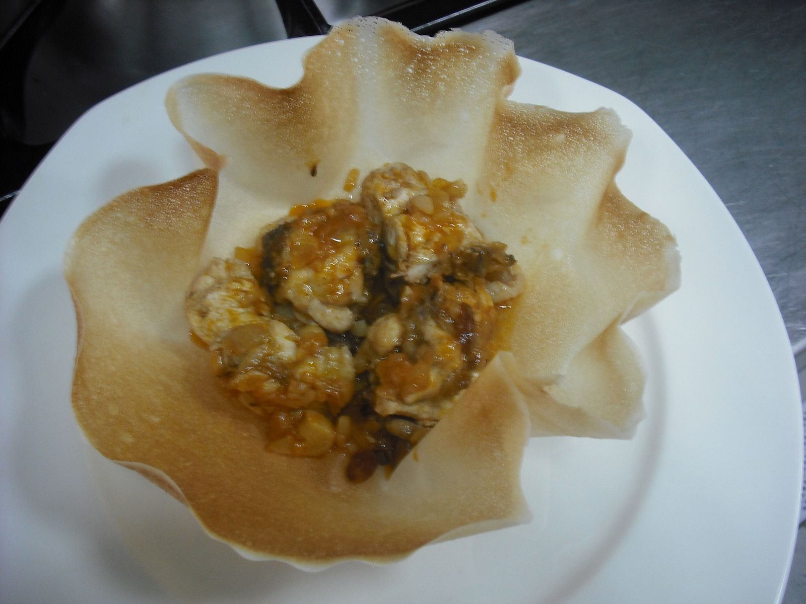 Pollo con frutos secos en cesta brick