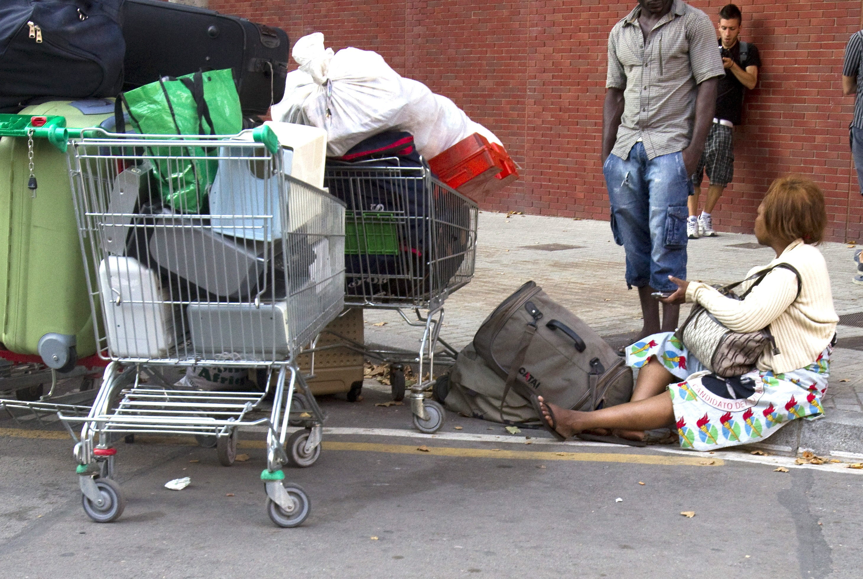 Mujer migrante en el suelo después de un desalojo