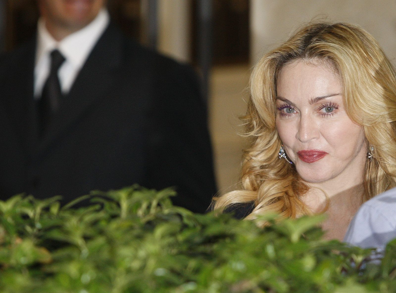U.S. singer Madonna looks on as she leaves the new Hard Candy Fitness centre in downtown Rome