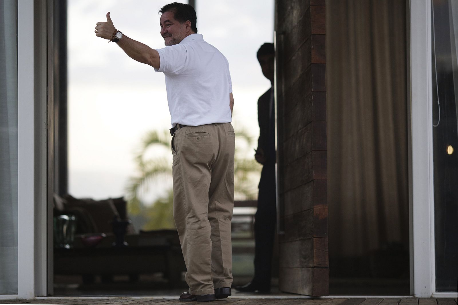 El senador boliviano Roger Pinto saluda con un gesto desde la entrada principal de la residencia del abogado Fernando Tiburcio en Brasilia.