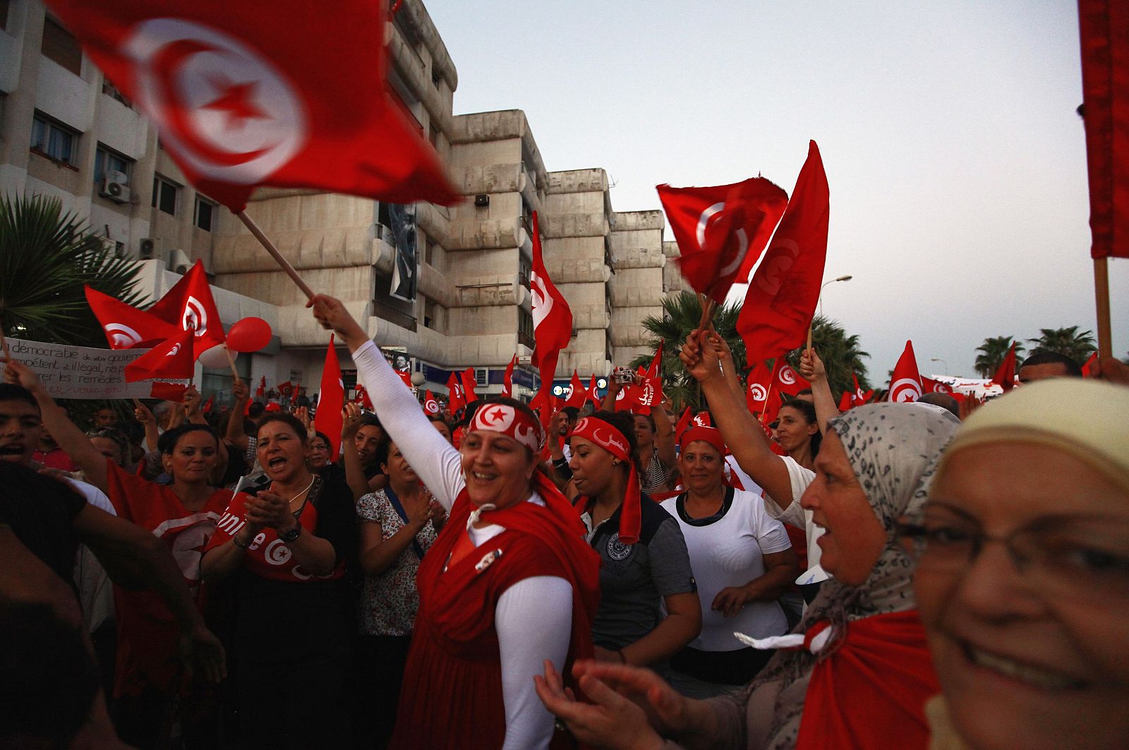 Anti-government protesters wave Tunisian flags and shout slogans during a demonstration in Tunis