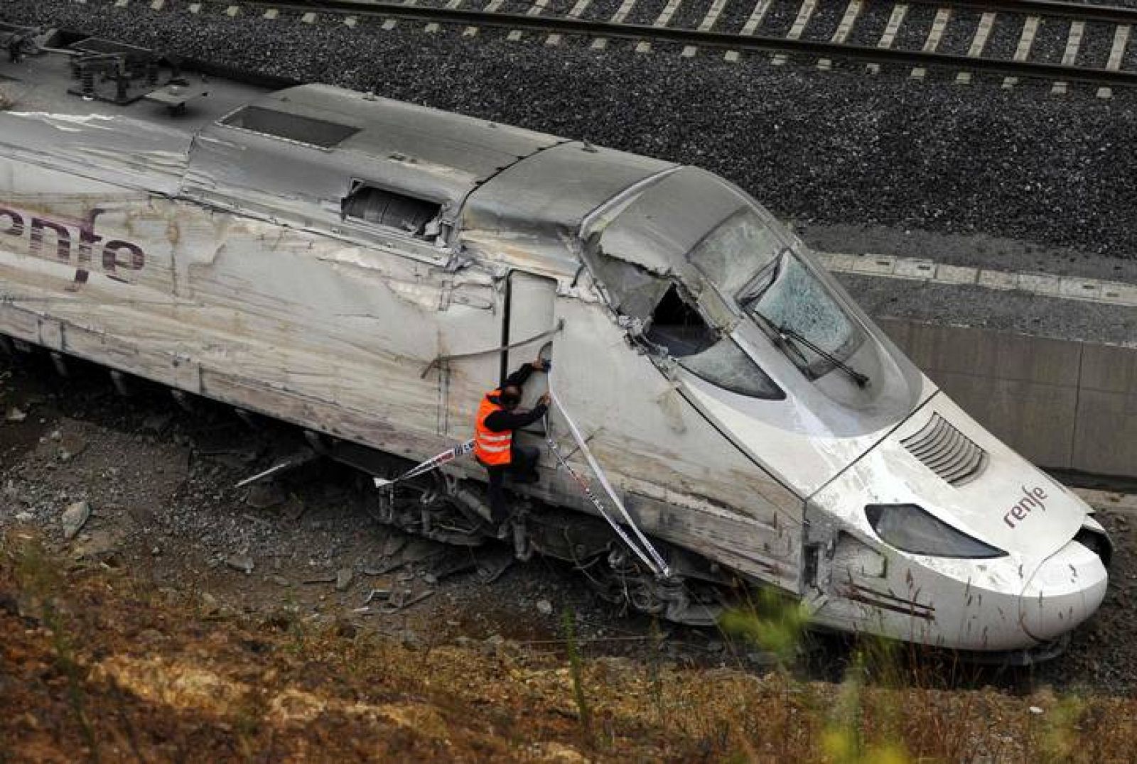 An official inspects the train engine amongst the wreckage of a train crash near Santiago de Compostela