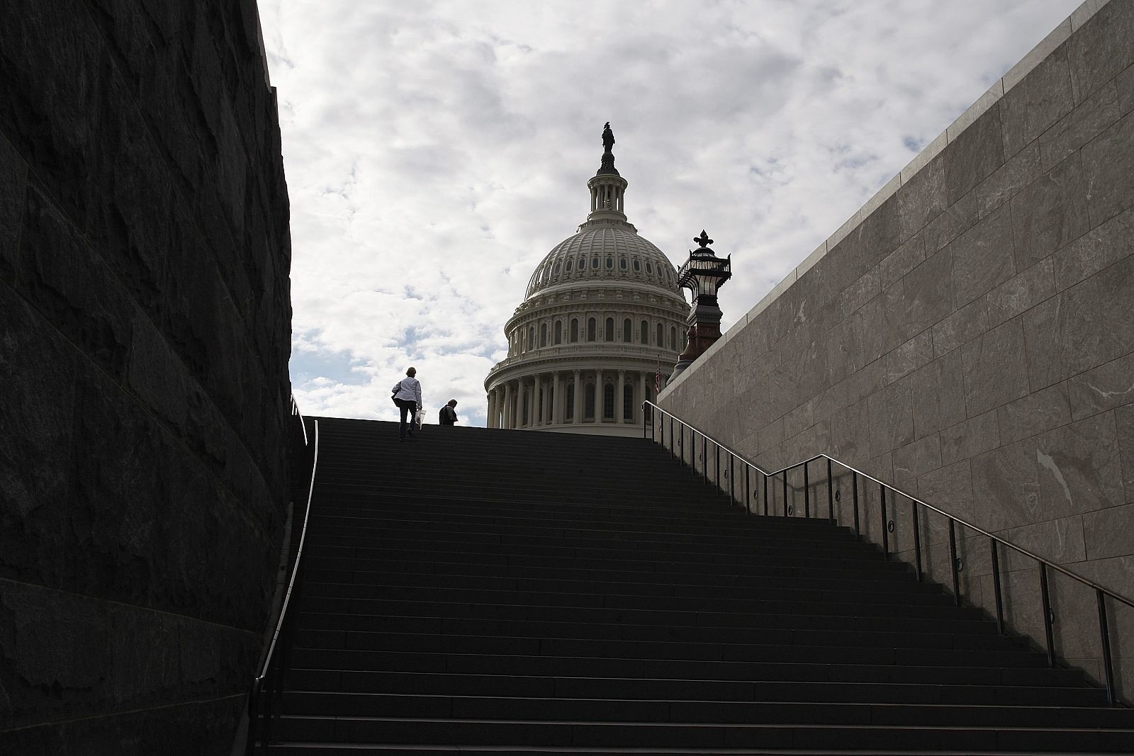 Varios paseantes suben la escalera hacia el Capitolio, en Washington