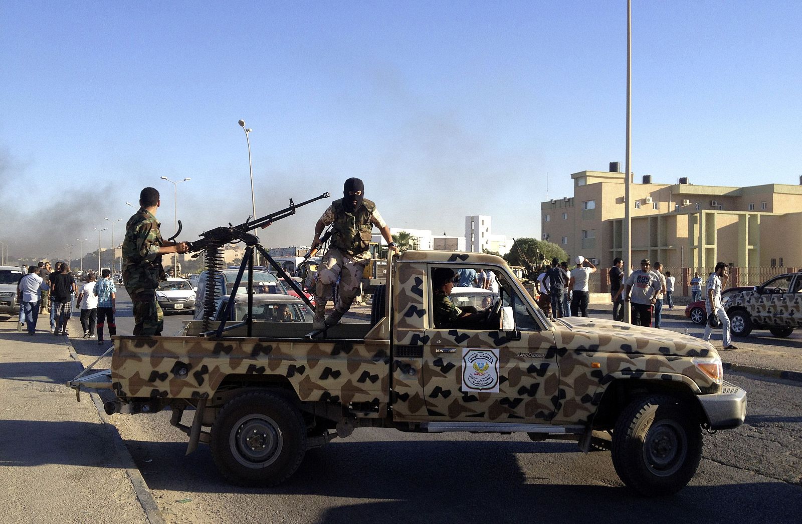 Members of the Libyan Army special forces who took military action against a militia group that took over public land, arrive on their vehicles, in Benghazi