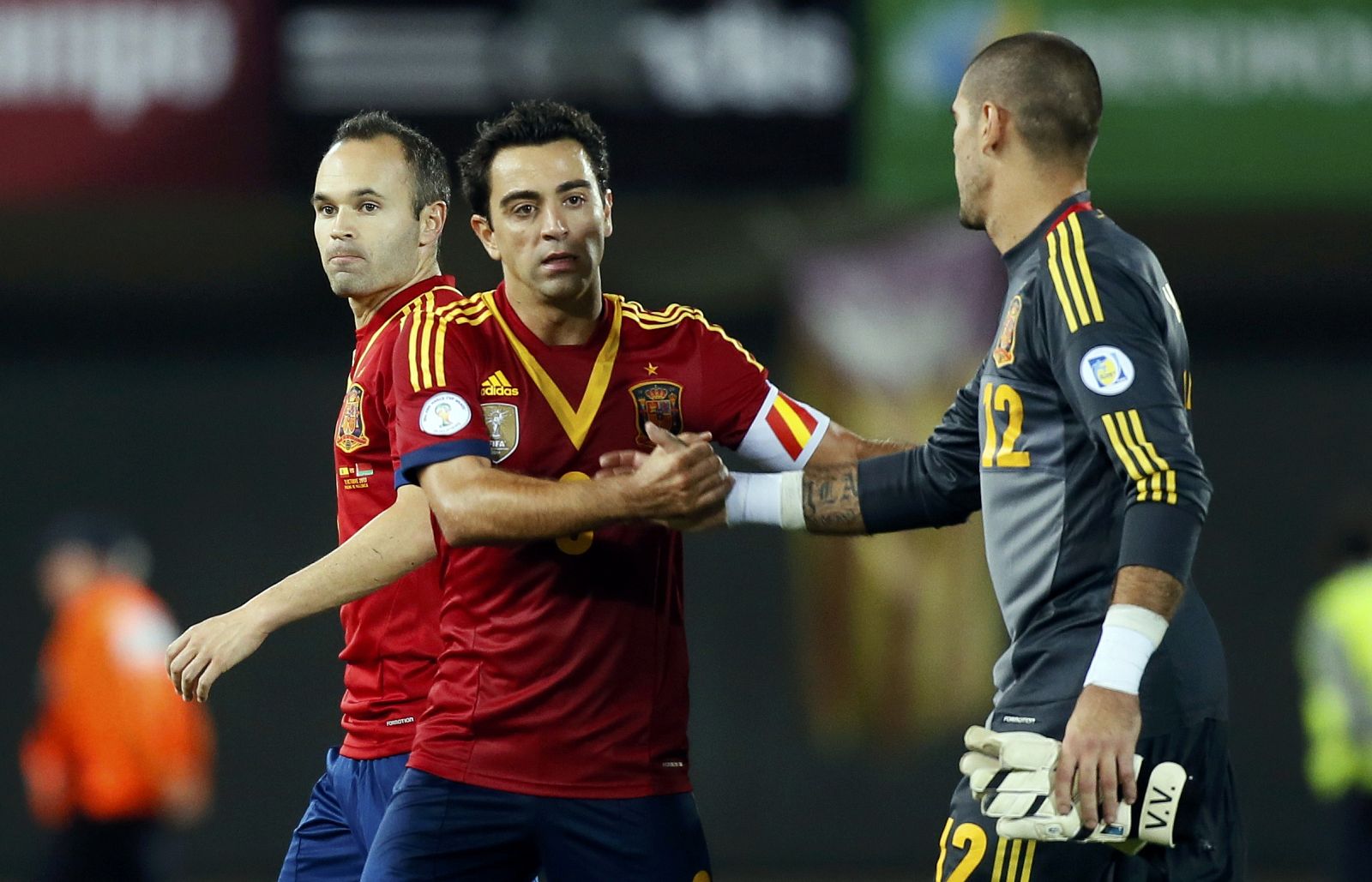 Spain's Xavi is greeted by goalkeeper Valdes as Iniesta looks on after their 2014 World Cup qualifying soccer match against Belarus in Spain