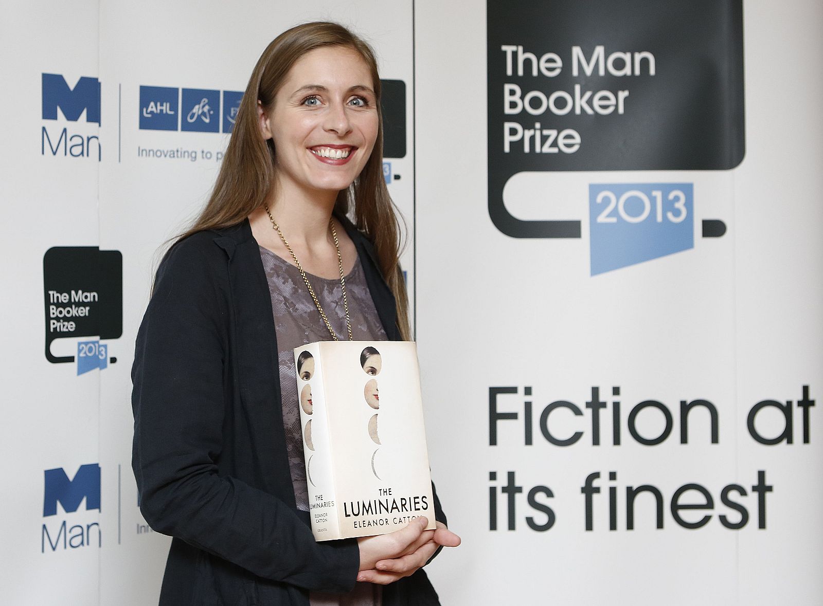 Man Booker prize shortlist nominee Eleanor Catton poses with her book "The Luminaries" during a photocall at the Southbank Centre in London