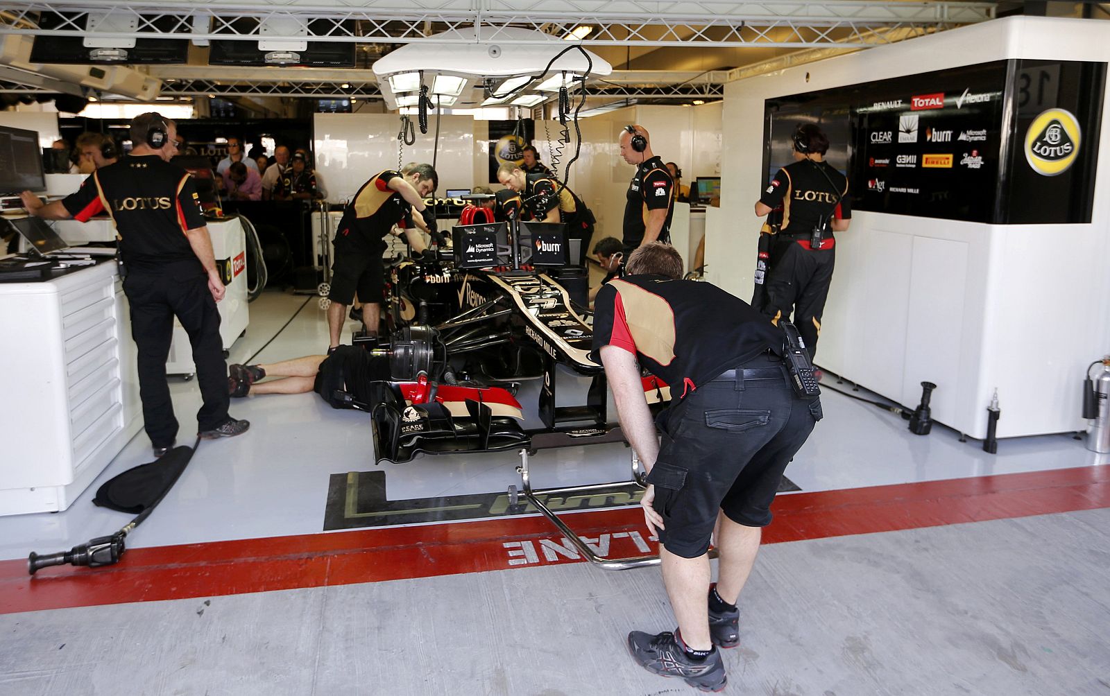 Mechanics work on the car of Lotus F1 Formula One driver Raikkonen of Finland before the third practice session of the Abu Dhabi F1 Grand Prix at the Yas Marina circuit on Yas Island