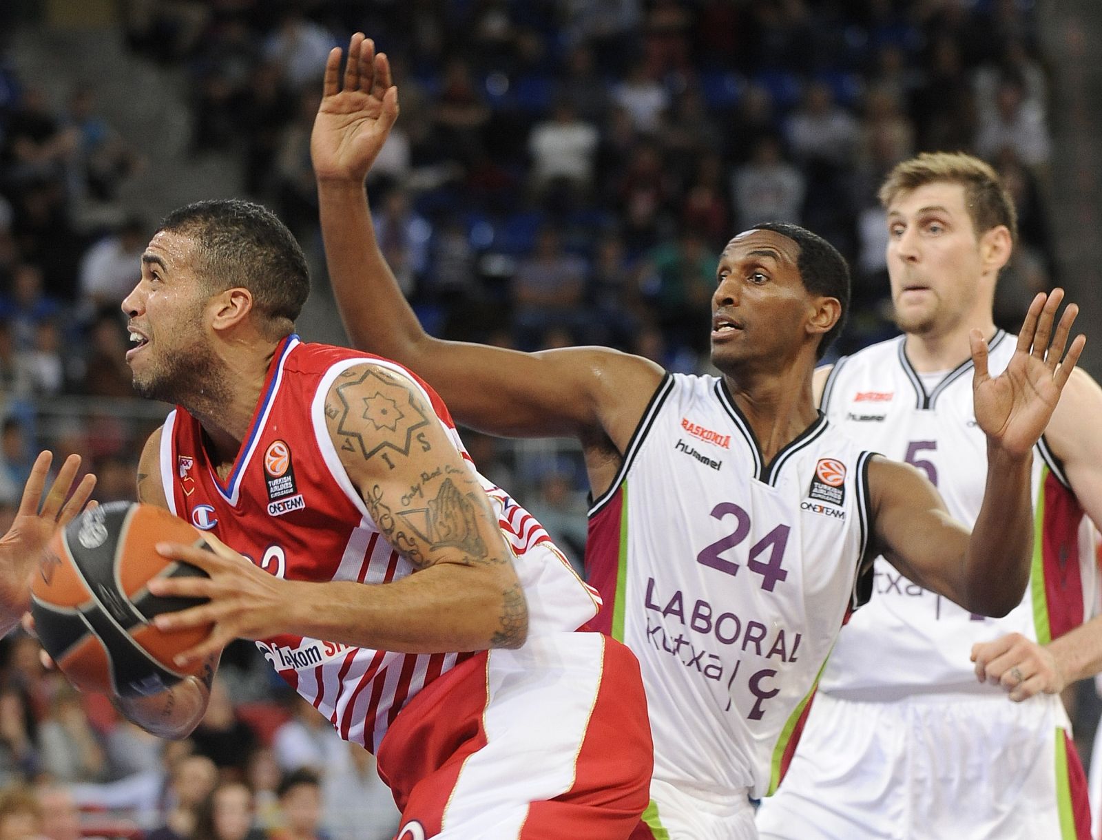 Blake Schilb (L) lucha con el base del Laboral Kutxa Thomas Kelati (C) durante el partido.