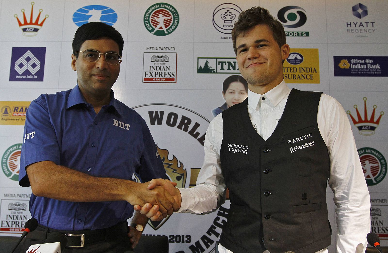 India's Anand shakes hands with Norway's Carlsen during joint news conference ahead of FIDE World Chess Championship in Chennai