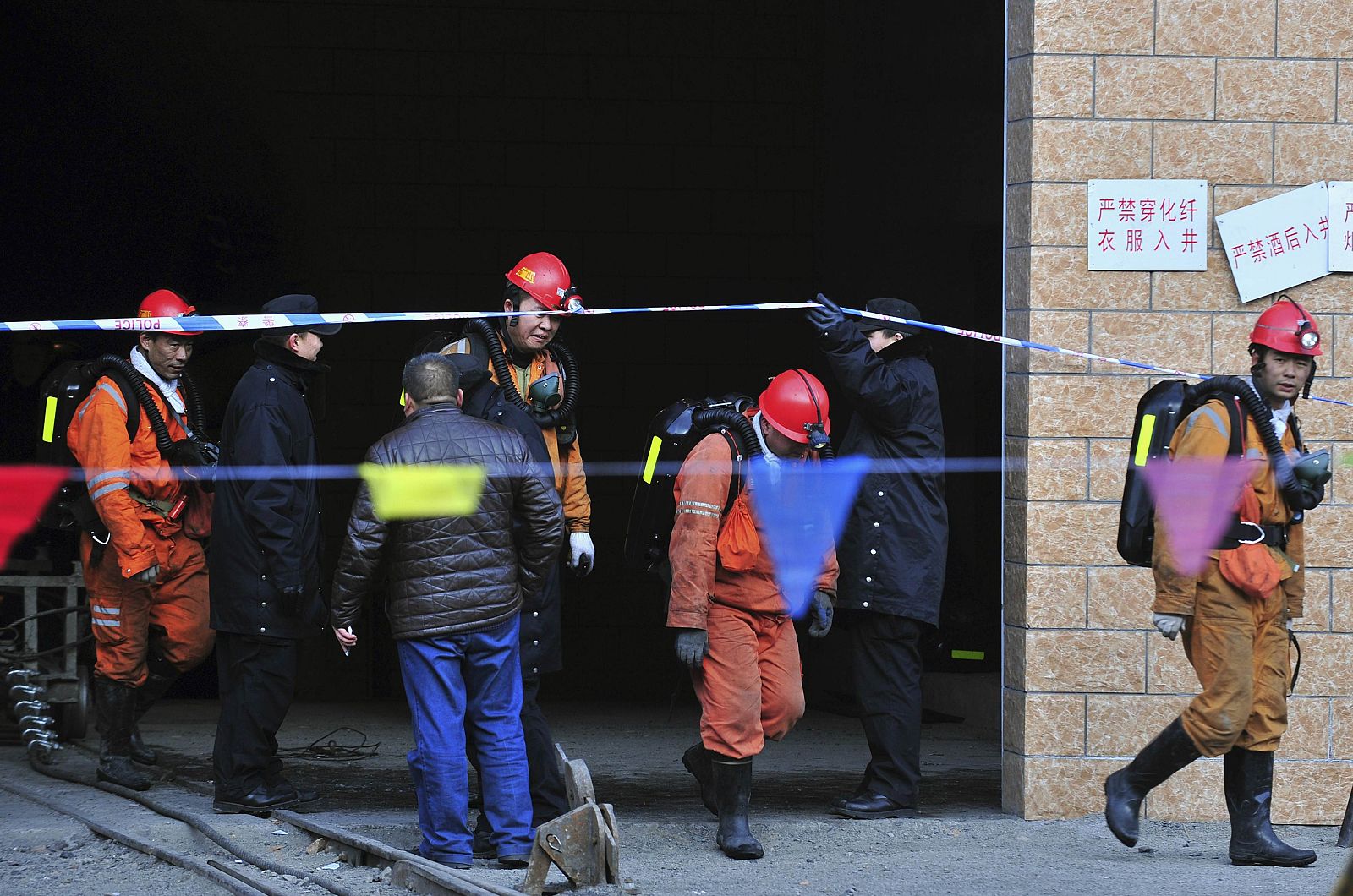 Rescuers walk out from the entrance to a coal mine after a gas explosion in Hutubi county