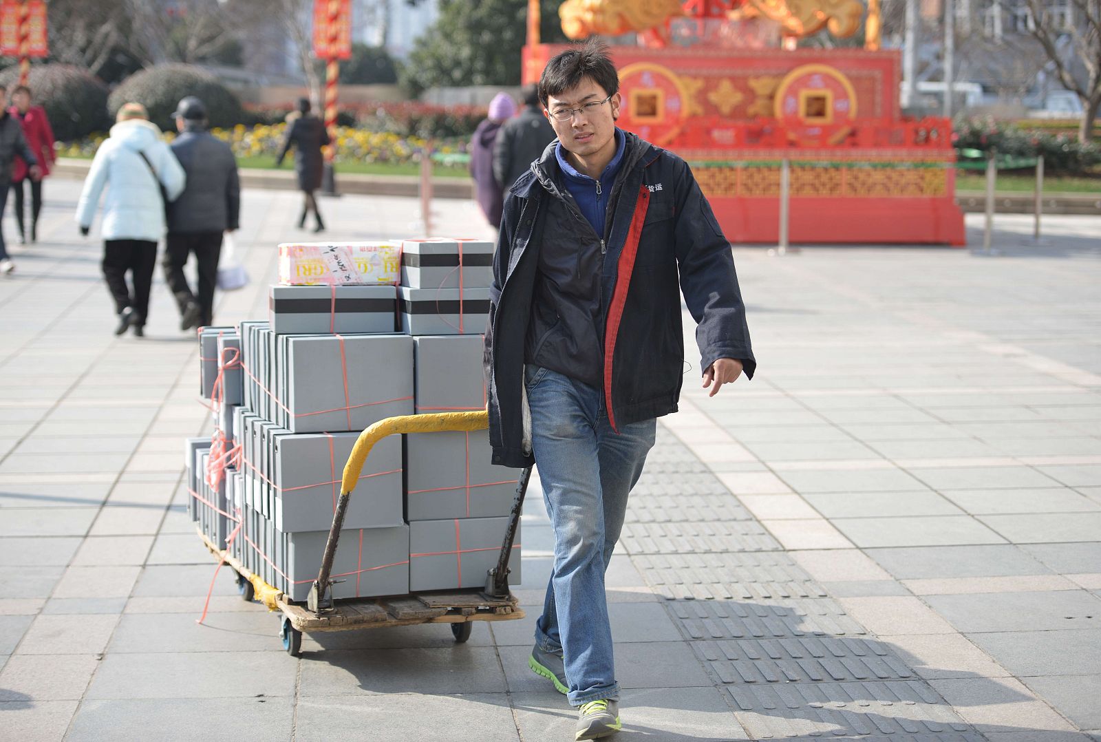 Un trabajador empuja un carro con mercancías en Sánghai