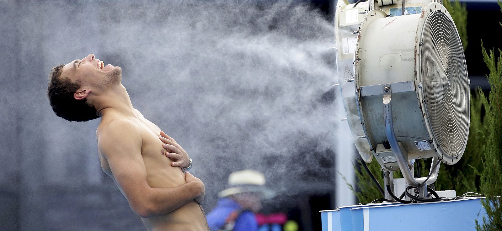 Handout picture of Jerzy Janowicz of Poland standing in front of a misting fan at the Grand Slam Oval at the Australian Open 2014 in Melbourne