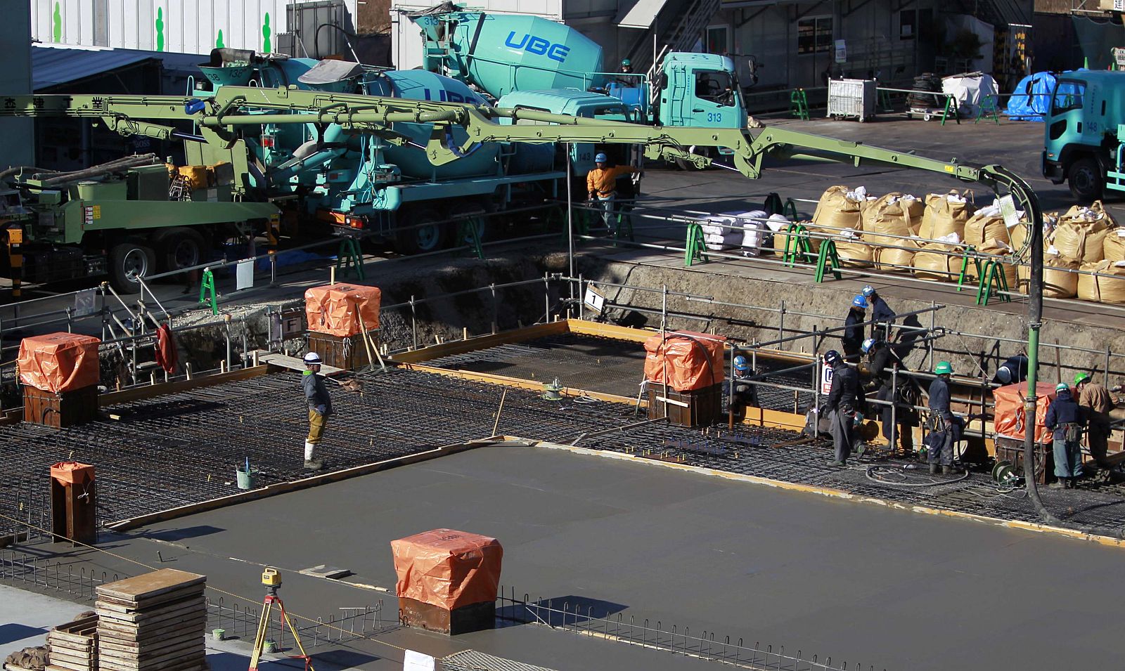 Labourers work among heavy machinery at a construction site in Tokyo