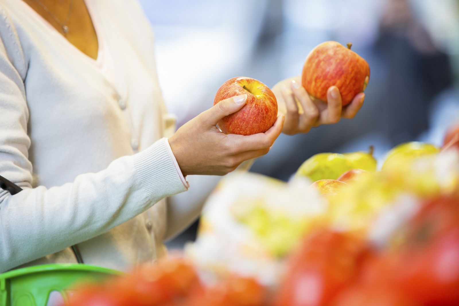 Mujer comprando frutas en un mercado.