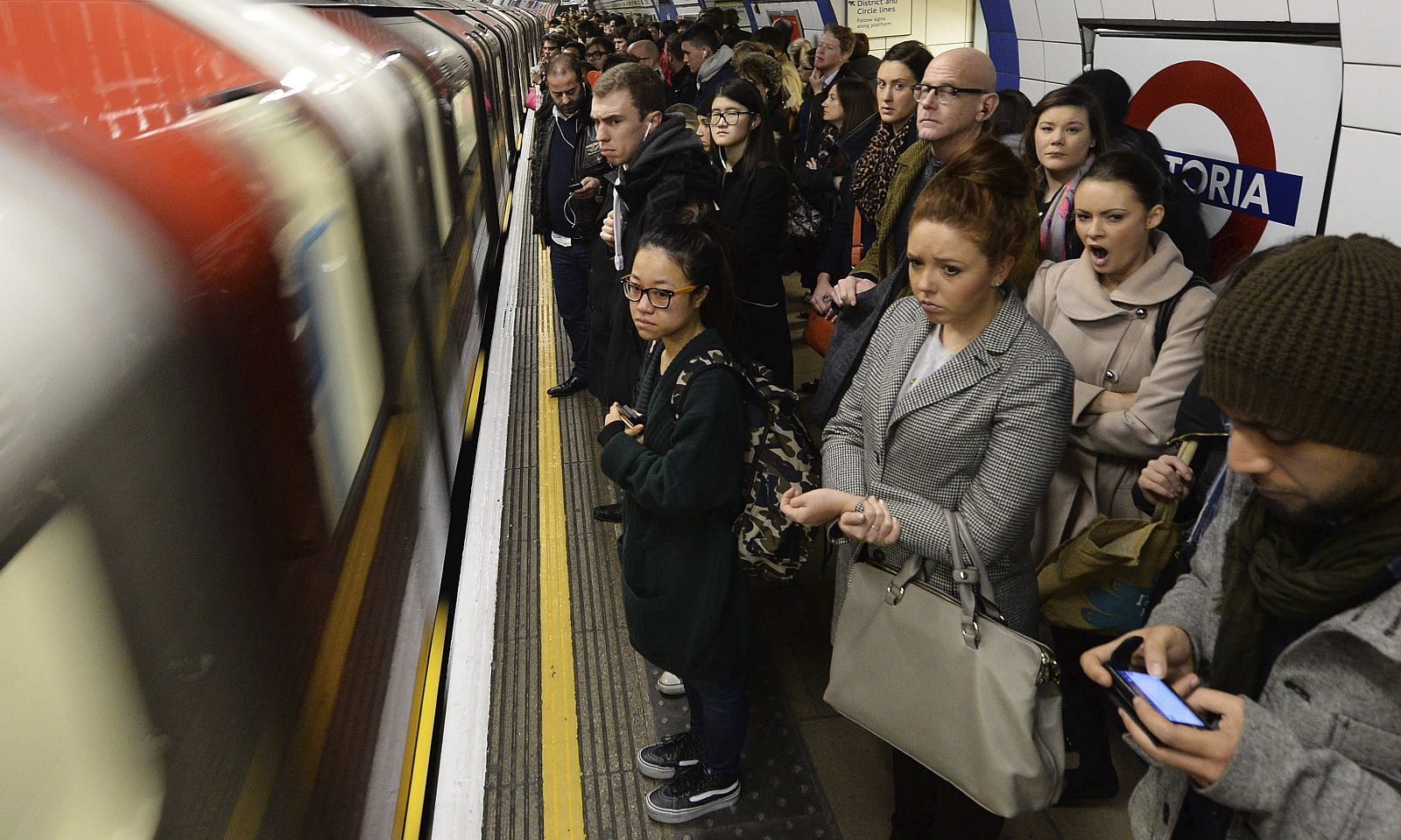 Viajeros se disponen a subir a bordo de un metro en la estación de Victoria en Londres (Reino Unido)
