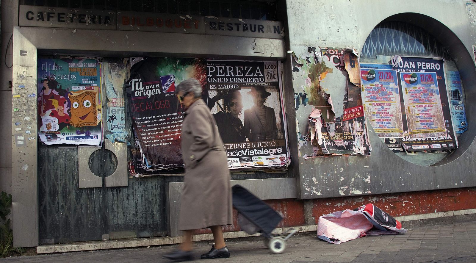 Una mujer pasa delante de un restaurante cerrado