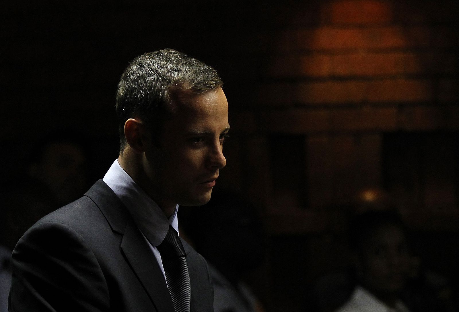 Oscar Pistorius stands in the dock ahead of court proceedings at the Pretoria magistrates court