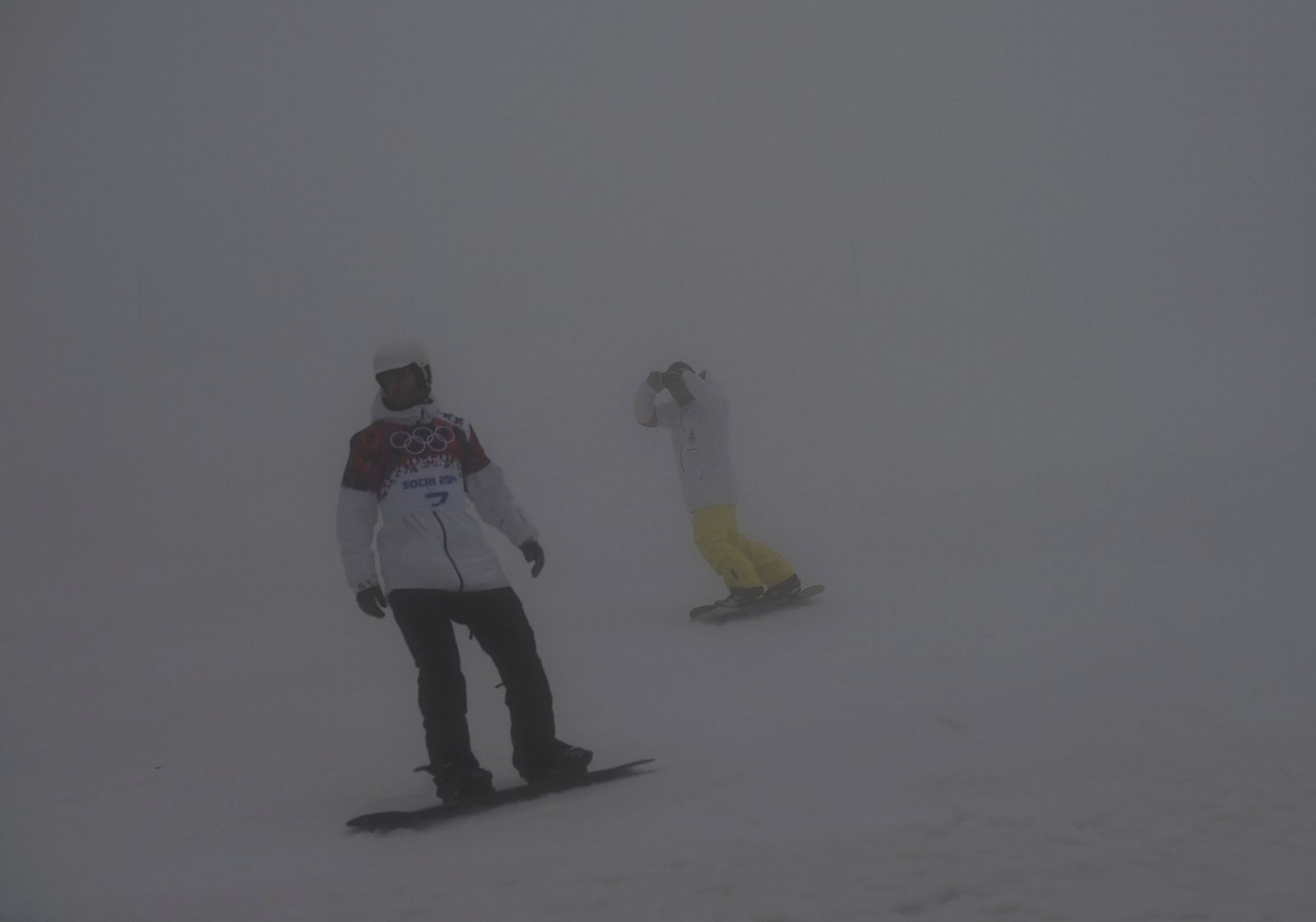 Snowboarders warm up in fog ahead of men's snowboard cross qualification round at 2014 Sochi Winter Olympic Games in Rosa Khutor