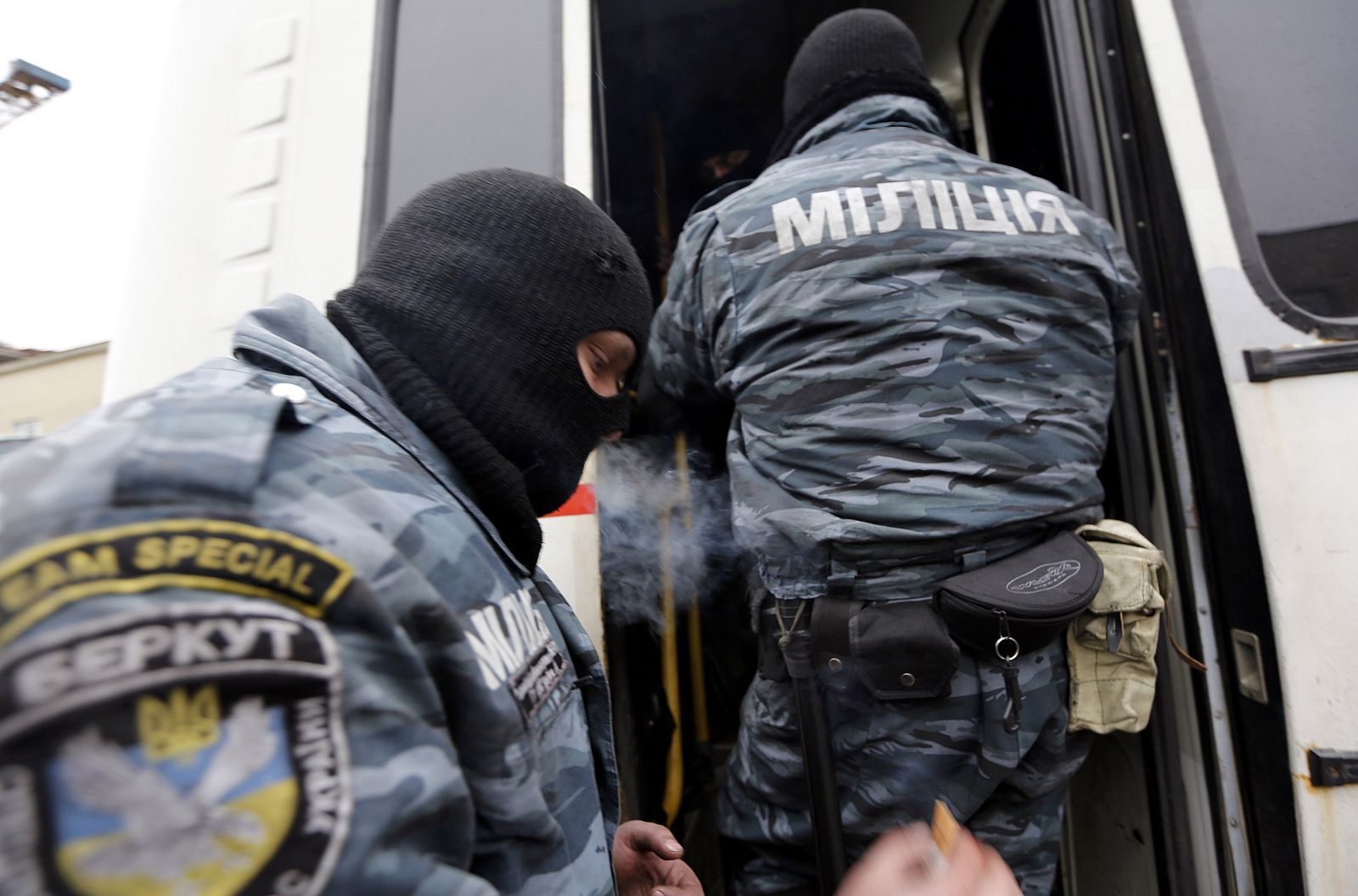 Members of Berkut anti-riot unit embark in a bus as leave their barracks in Kiev