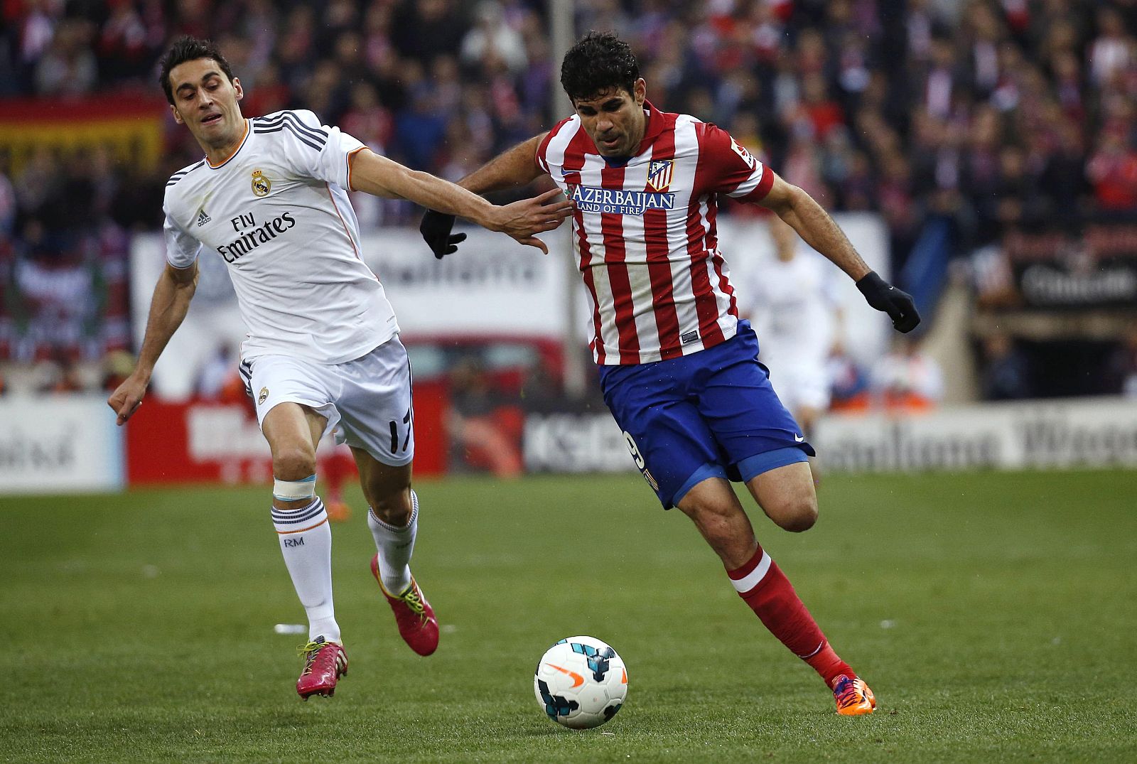 Real Madrid's Arbeloa and Atletico Madrid's Costa challenge for the ball during their Spanish first division soccer match in Madrid