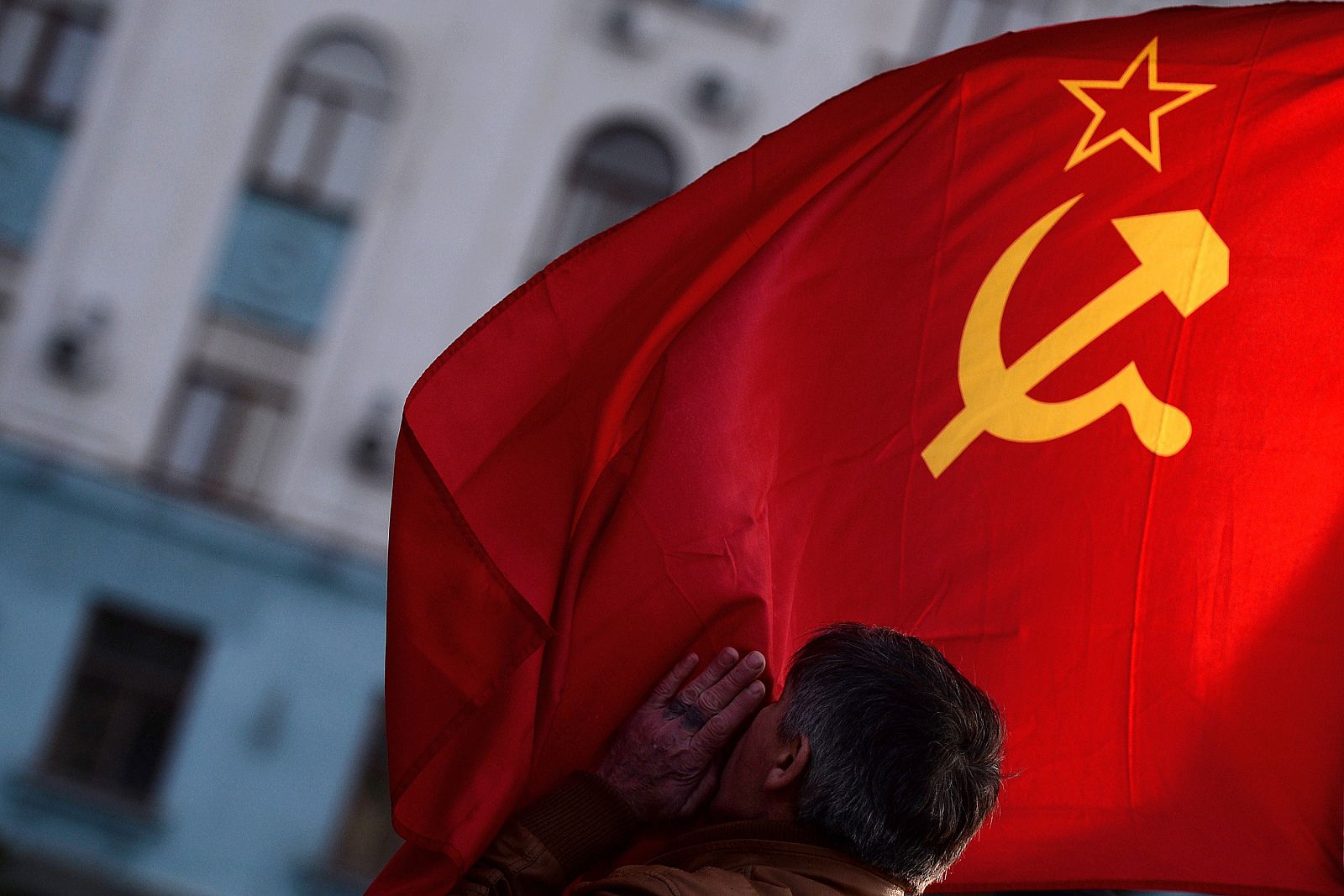 Un hombre besa la bandera de la URSS en Simferópol, capital de Crimea