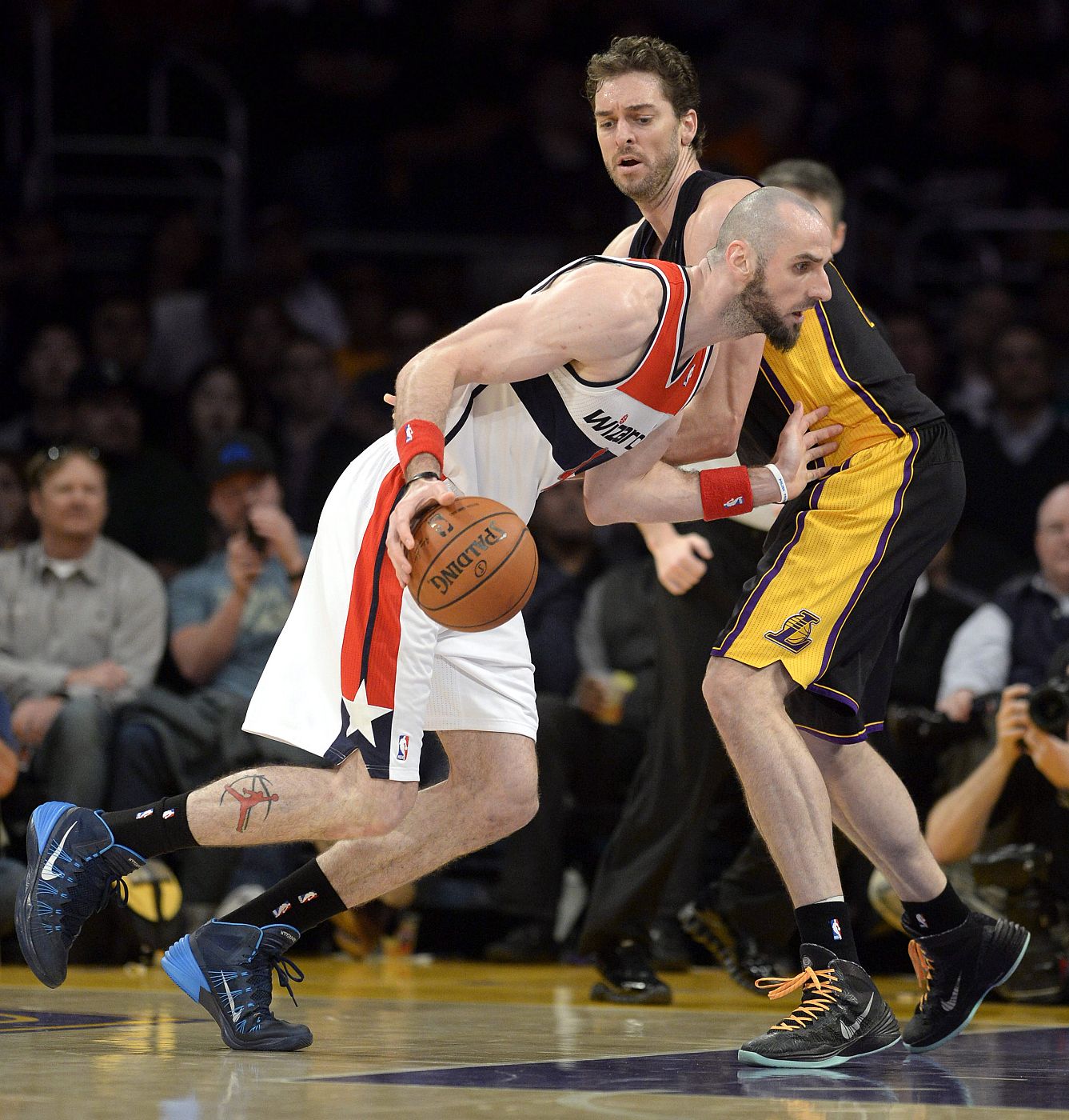 Marcin Gortat, de los Wizards, protege el balón ante la defensa de Pau Gasol