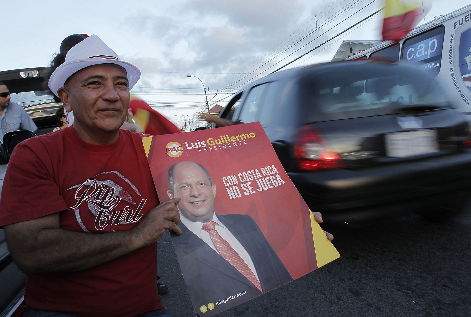 A supporter holds a poster of Luis Guillermo Solis, presidential candidate of the Citizens' Action Party, during the presidential election run-off in San Jose