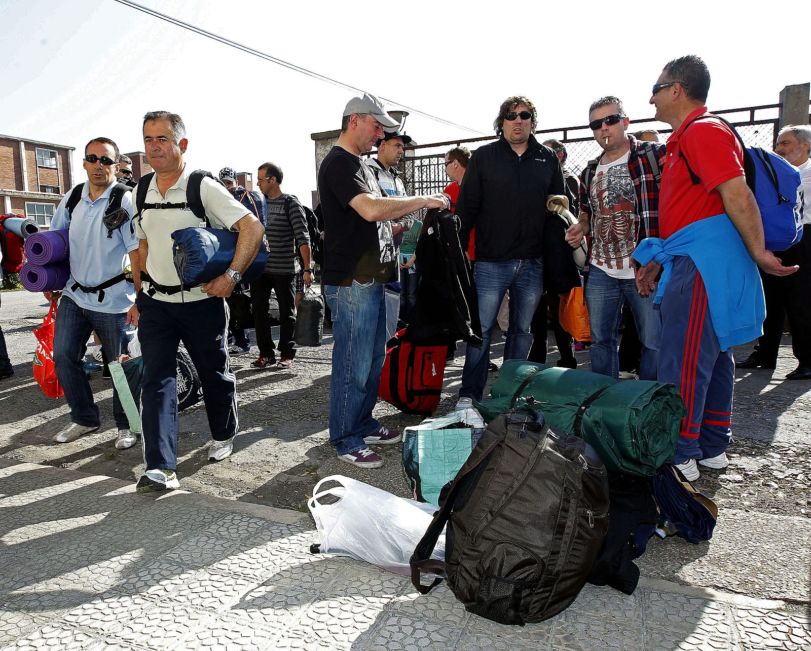 Algunos de los trabajadores de Sniace junto a sus pertenencias momentos antes de iniciar un encierro en la fábrica