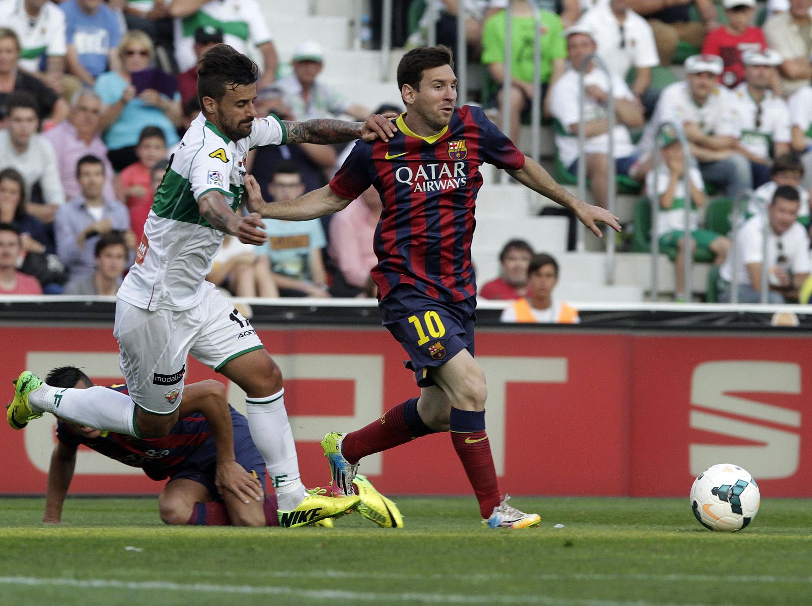 Barcelona's Messi and Elche's Marquez fight for the ball during their Spanish first division soccer match at the Martínez Valero stadium in Elche