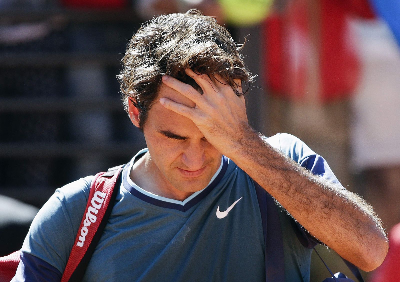 Federer of Switzerland leaves the court after been defeated by Chardy of France during their men's singles match at the Rome Masters tennis tournament