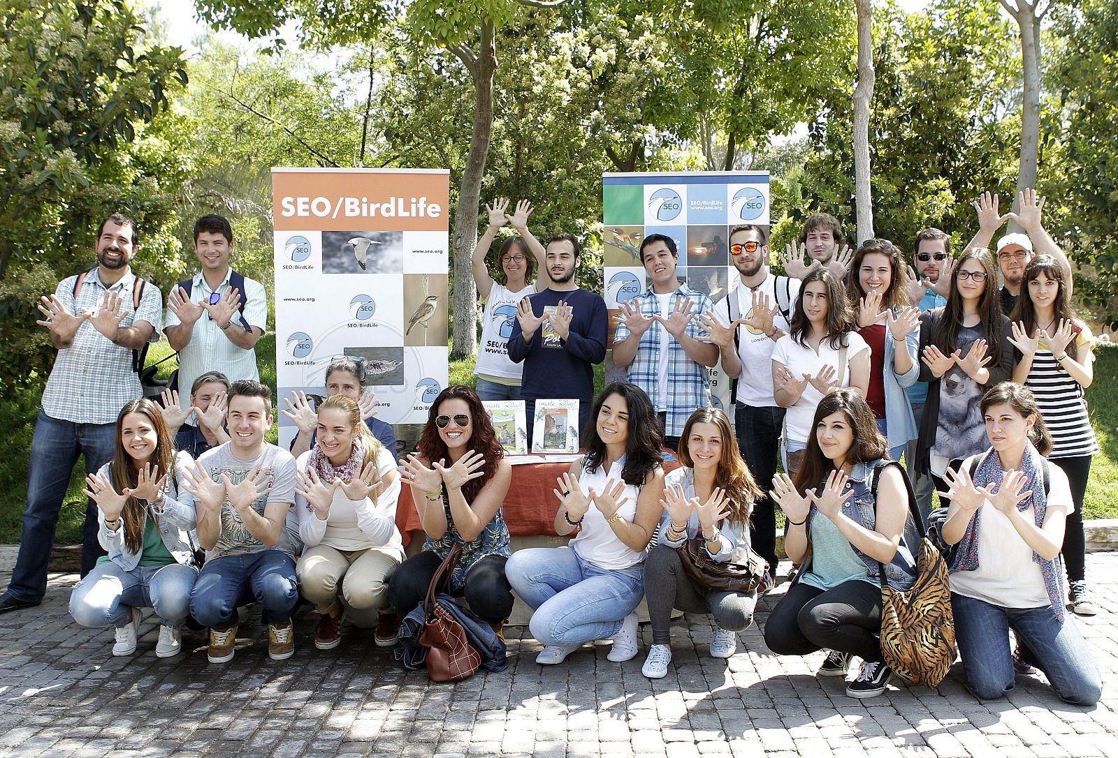 Estudiantes de veterinaria hacen el gesto de la mariposa por el Día Europeo de la Red Natura 2000 en el Bioparc de Valencia.