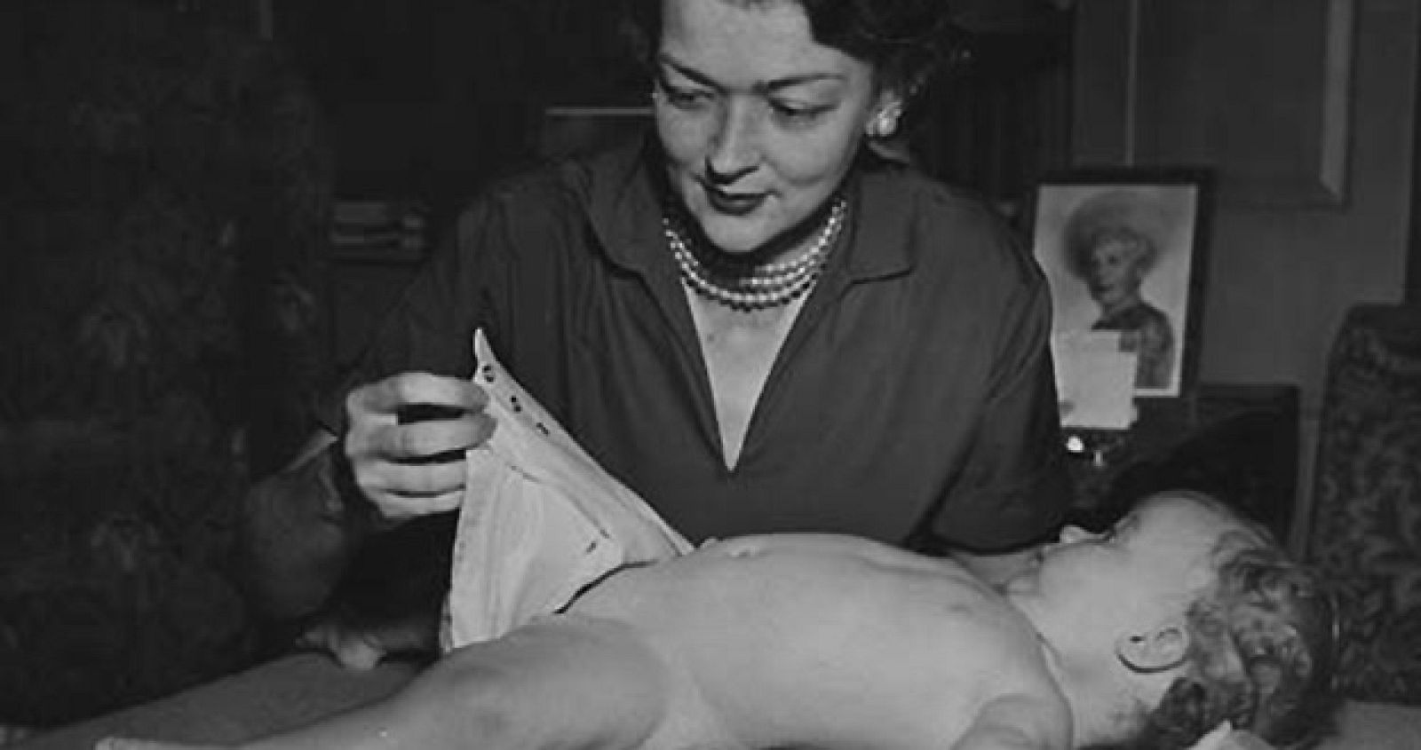 La inventora del pañal desechable probandolo a un bebé