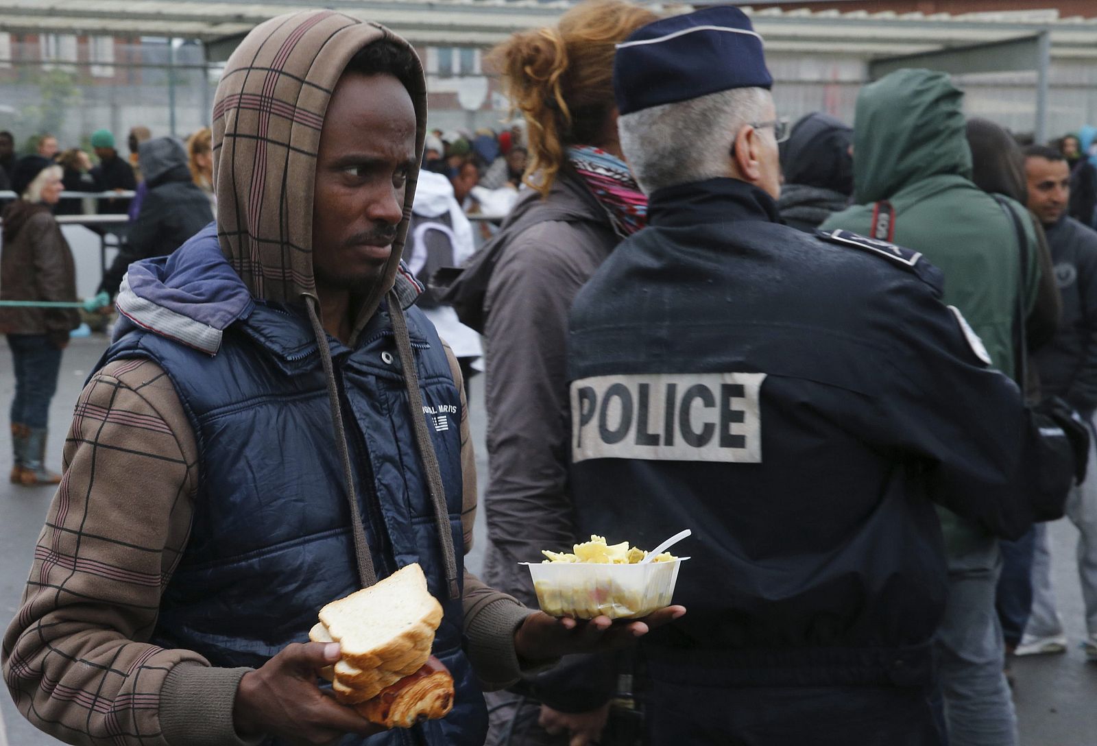 Un migrante eritreo junto a un policía en Calais, norte de Francia