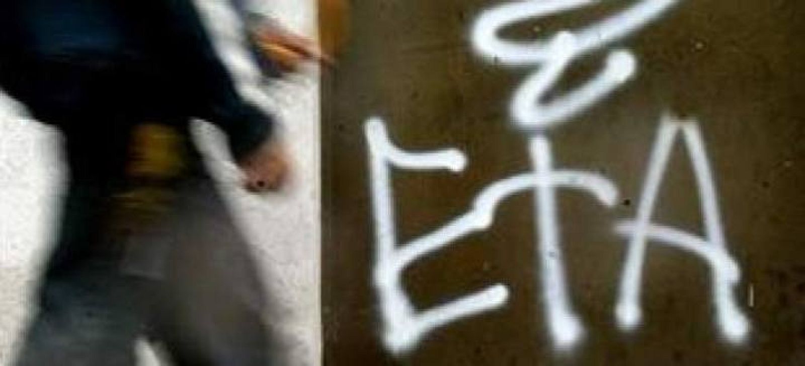 Una persona pasa junto a una pintada del logo de la banda terrorista ETA
