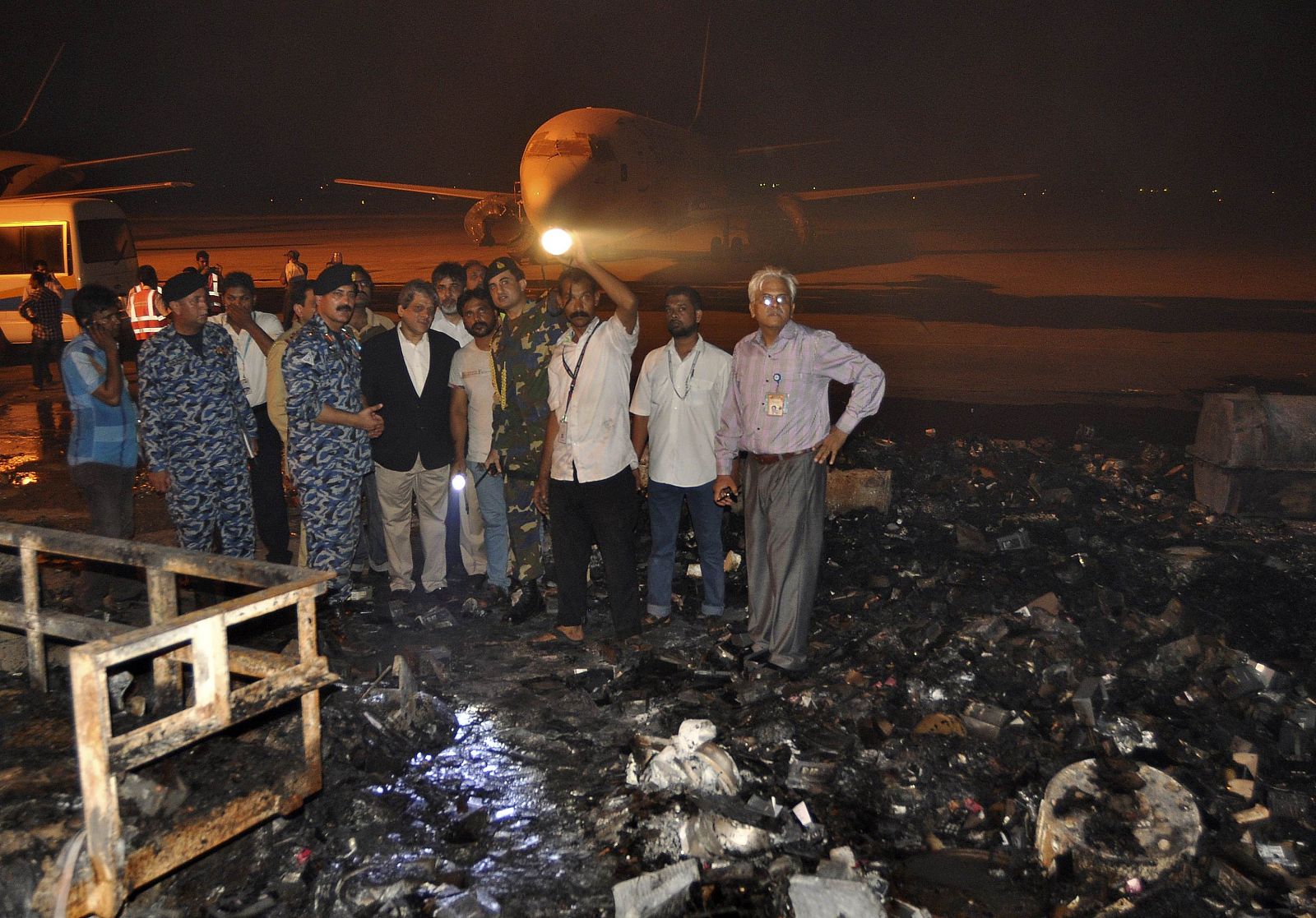 El gobernador de la provincia paquistaní de Sindh, Ishrat ul Ebad (con traje) visita el aeropuerto de Karachi donde se produjo el ataque de los talibanes