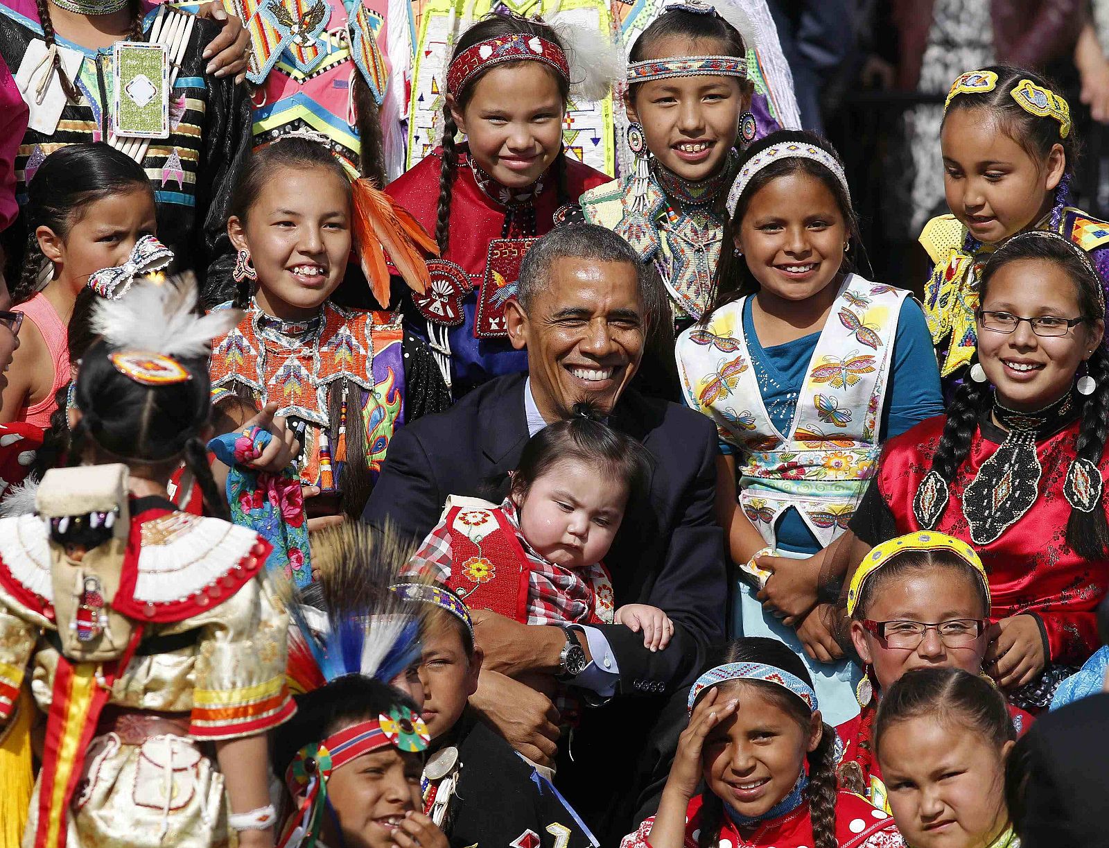 U.S. President Obama holds a baby as he poses with children at Cannon Ball Flag Day Celebration in Standing Rock Sioux Reservation in North Dakota