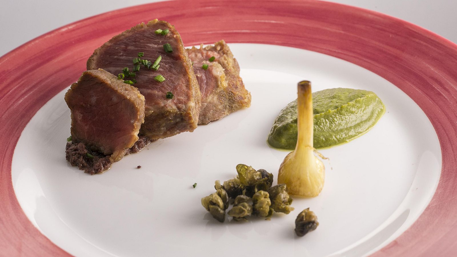 Presa ibérica con puré de berza , aceitunas negras y perrichicos