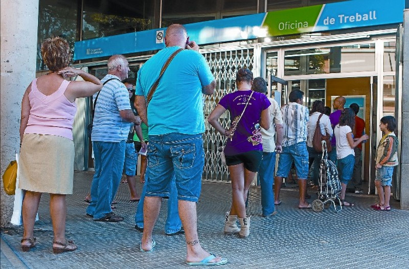 Imagen de archivo de unos desempleados frente a una oficina de empleo de Cataluña