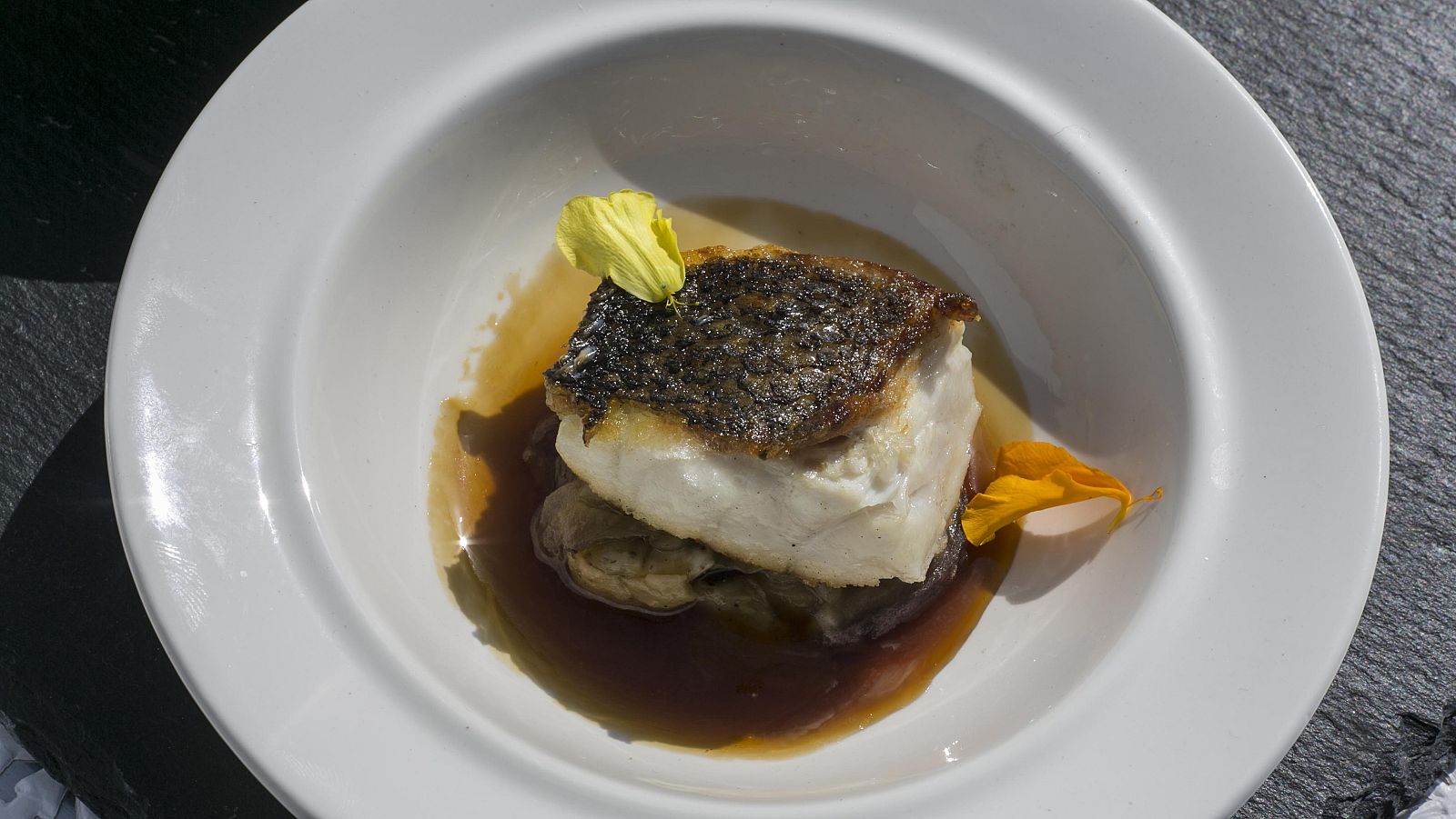 Lubina salvaje con berenjena asada y caldo de setas