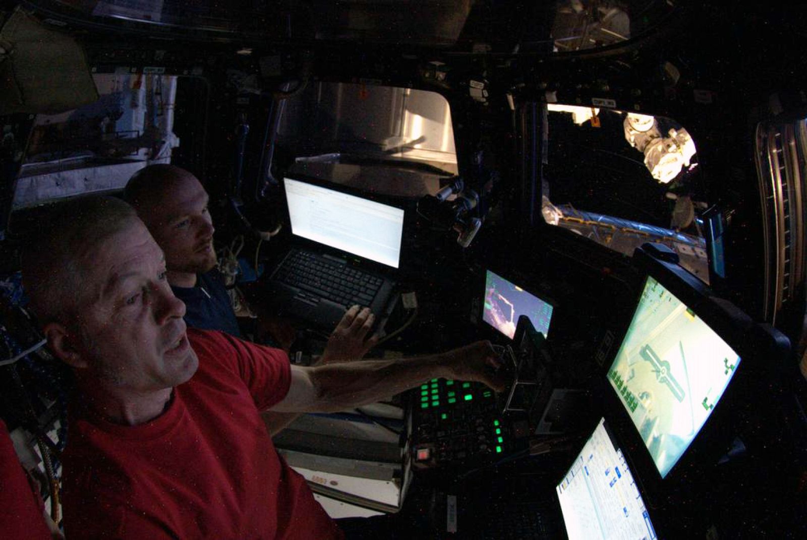 El ingeniero de vuelo Alexander Gerst (primer plano) y el comandante Steve Swanson operan con el brazo robot de la Estación.