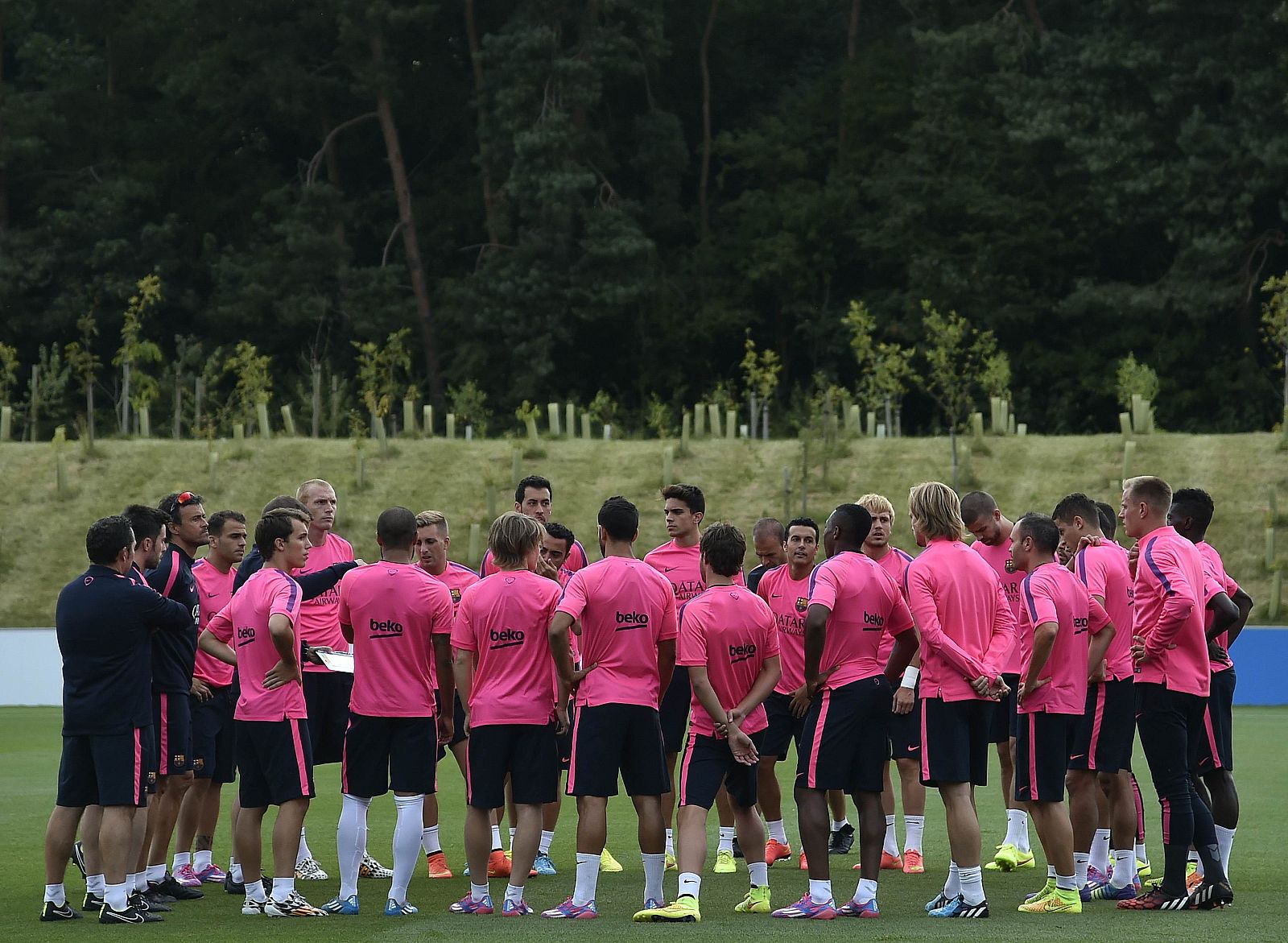 Barcelona's coach Luis Enrique speaks with his players during a training session at St. George's Park near Burton on Trent