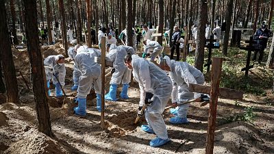 Equipos forenses exhuman los cuerpos del enterramiento masivo de Izium e investigan posibles crímenes de guerra